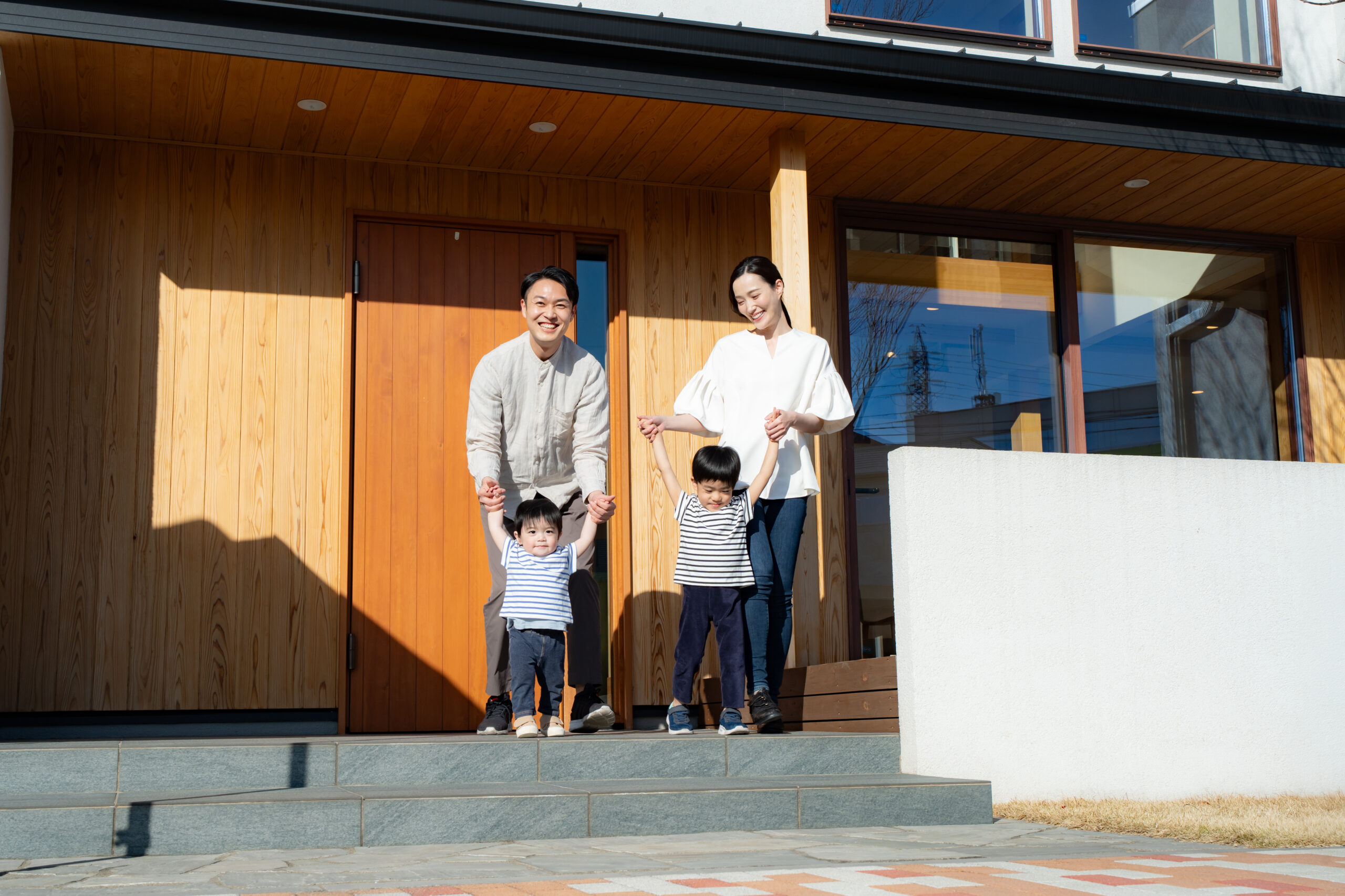 戸建て住宅の前にいる家族｜住宅の物件見学イメージ