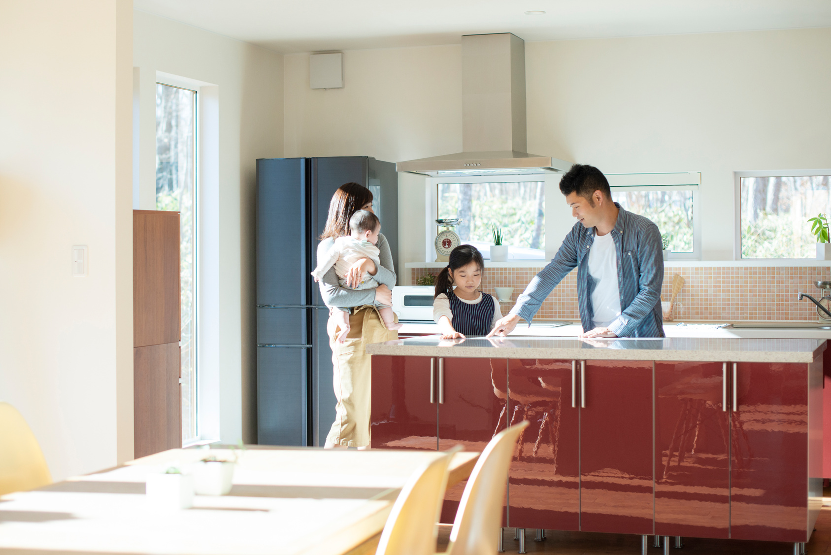 キッチンを見学する家族｜住宅の間取り・生活動線を確認するイメージ